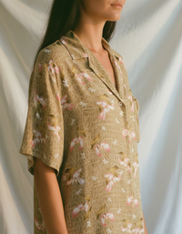 Woman wearing a floral  shirt dress with a neutral background