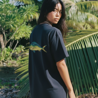 Woman wearing a black t-shirt with a fish design in a tropical setting